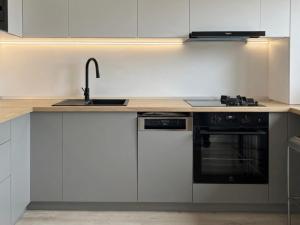 a kitchen with white cabinets and a sink and a stove at ANON Mures in Livezeni