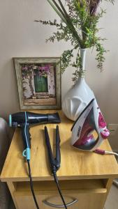 a table with a hair dryer and a vase with flowers at Apê estiloso e funcional no coração da cidade in Porto Velho