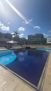 a large swimming pool with blue water in front of buildings at Apê estiloso e funcional no coração da cidade in Porto Velho