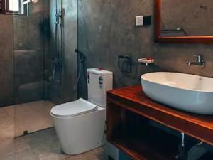 a bathroom with a toilet and a sink and a shower at Spacious 2 Bedroom Apartment with Lake View in Tangalle