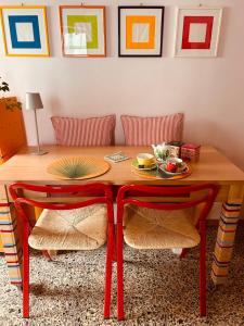 a dining room table with two red chairs and a table at Il balconcino di Riamori in Amelia