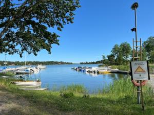 a marina with boats in the water with a warning sign at Swedish cottage near ocean in Norrtälje