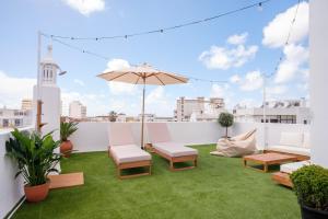 a rooftop patio with grass and an umbrella at Casa Rosa Sé - Luxury Boutique Guest House in Faro