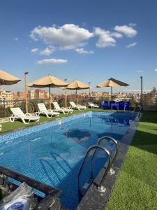 a large swimming pool with chairs and umbrellas at The Grand Delta Hotel in Cairo