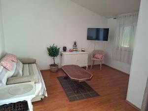 a living room with a couch and a tv at Apartman Marito in Kaštela