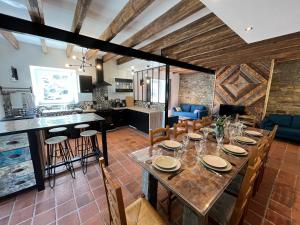 a dining room and kitchen with a long table and chairs at L'échappée in Neulliac