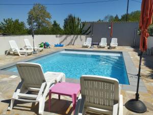 a swimming pool with chairs and a table and a lamp at Chambre 2 pers SPA Piscine in Grospierres