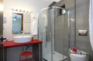 a bathroom with a shower and a sink and a toilet at Milos Paradise Luxury Villas in Agios Nikitas