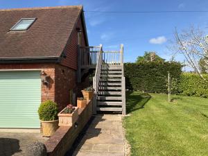 a brick house with a staircase leading to a garage at Loft apartment in Herstmonceux