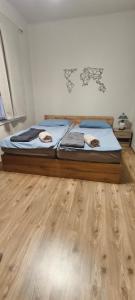 a bed sitting on top of a wooden floor at Anna Vendégház in Kápolnásnyék