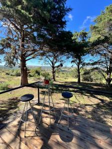 a table and two stools in front of a tree at NuestroSueño in Villa Serrana
