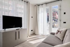 a living room with a flat screen tv on a cabinet at Nuovo appartamento in centro a Darfo Boario Terme in Boario Terme