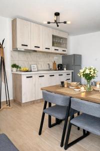 a kitchen with white cabinets and a wooden table at Balis House in Theológos