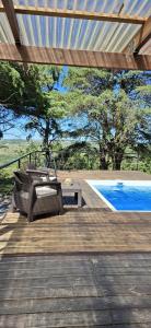 a deck with a table and chairs next to a pool at NuestroSueño in Villa Serrana