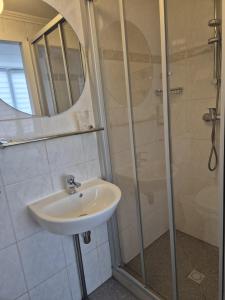 łazienka z umywalką i prysznicem w obiekcie Hotel Corel w Scheveningen +36 zdjęć