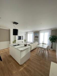 a kitchen and living room with white furniture and a table at Belle escale by LV in Dieppe