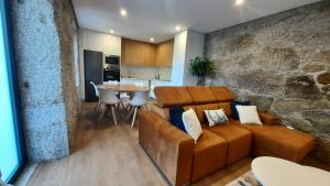 a living room with a brown couch and a table at Casas Peralta - Outeiro in Arouca
