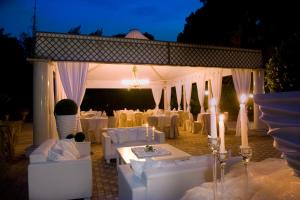 a room with a table, chairs, and tables with umbrellas at Park Hotel Villaferrata in Grottaferrata