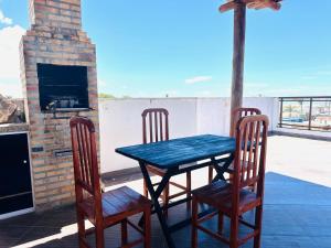 a table and chairs on a porch with a fireplace at 4 Ventos House in São Miguel do Gostoso