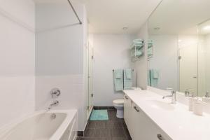 a bathroom with two sinks and a tub and a toilet at Urban Explore in Toronto +30 photos