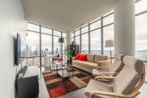 a living room with a couch and chairs and windows at Urban Explore in Toronto
