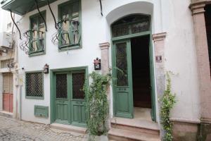 a building with green doors on a street at Defne Pansiyon Ayvalık in Ayvalık