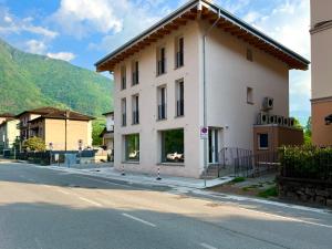 a white building on the side of a street at Nuovo appartamento in centro a Darfo Boario Terme in Boario Terme