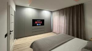 a bedroom with a bed and a tv on a wall at ANON Mures in Livezeni