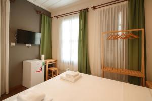 a room with a bed and a refrigerator and a window at Defne Pansiyon Ayvalık in Ayvalık +20 photos