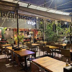 a restaurant with wooden tables and chairs and lights at Apt Areia e Maré in Maceió