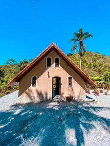 a house with a palm tree in front of it at Chalé Espaço Raiz de Lumiar in Nova Friburgo