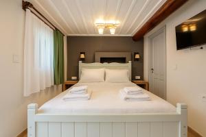 a bedroom with a white bed with two towels on it at Defne Pansiyon Ayvalık in Ayvalık