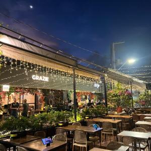a restaurant with tables and chairs and lights at Apt Areia e Maré in Maceió
