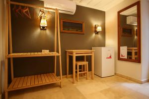 a room with a refrigerator and a table and stool at Defne Pansiyon Ayvalık in Ayvalık