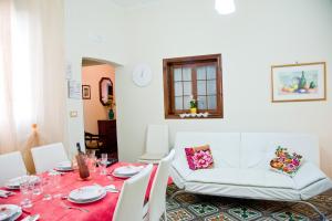 a dining room with a table and a couch at La Casa di Baldo in Ugento