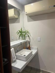 a bathroom with a white sink and a mirror at Apt Areia e Maré in Maceió +50 photos