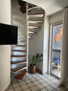 a spiral staircase in a living room with a tv at Apt Areia e Maré in Maceió