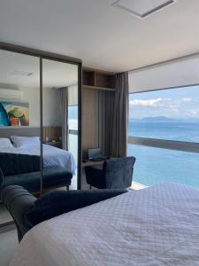 a bedroom with a bed and a view of the ocean at Vilella Vista Bela in Angra dos Reis