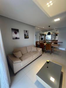 a living room with a couch and a table at LRFlat - Ambiente climatizado, moderno, confortável e próximo a tudo! in Montes Claros