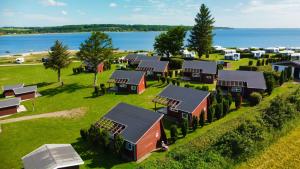 an aerial view of a farm with houses and the water at Vikær Strand Camping & Cottages in Diernæs