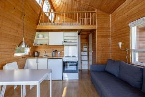 a kitchen and living room with a couch and a table at Vikær Strand Camping & Cottages in Diernæs