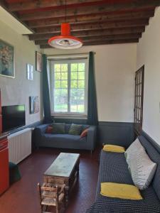 a living room with a couch and a table at Gîte de la Ferme Feugère in Barbeville