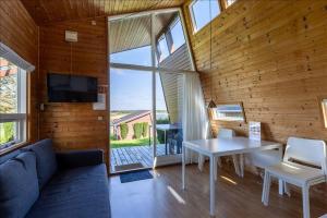a living room with a couch and a table and a tv at Vikær Strand Camping & Cottages in Diernæs