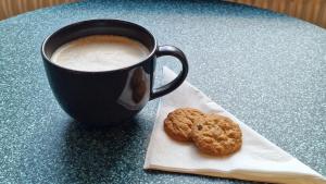 a cup of coffee and two cookies on a napkin at HOTEL N Hostel Malmö City in Malmö