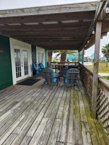 a wooden deck with chairs and a table at Palms Getaway in Freeport