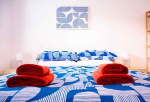 a bed with red towels on top of it at Rosa's Retreat - By Rowes Retreats in Falmouth