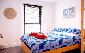 a bedroom with a bed with red pillows on it at Rosa's Retreat - By Rowes Retreats in Falmouth