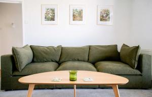 a living room with a green couch and a coffee table at Rosa's Retreat - By Rowes Retreats in Falmouth
