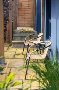 two chairs and a table in front of a door at Rosa's Retreat - By Rowes Retreats in Falmouth +51 photos