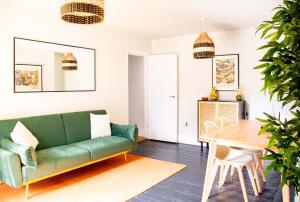 a living room with a green couch and a table at Rosa's Retreat - By Rowes Retreats in Falmouth